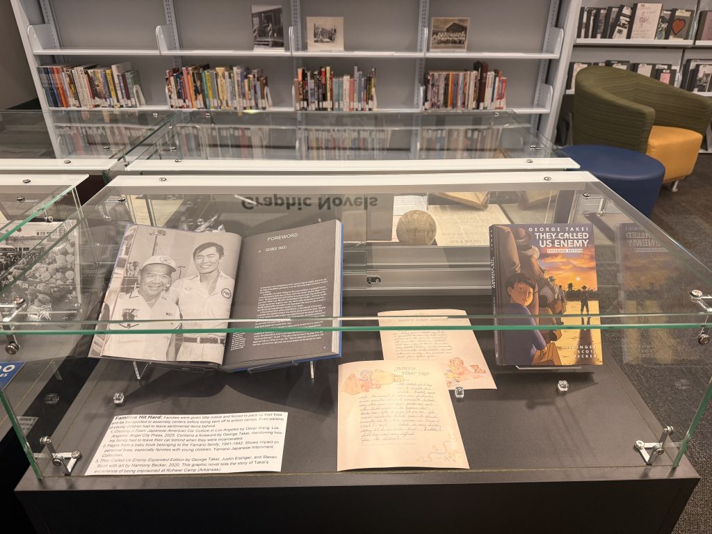 Individual image of the second exhibit case. Includes the book 'They Called Us Enemy' by George Takei.